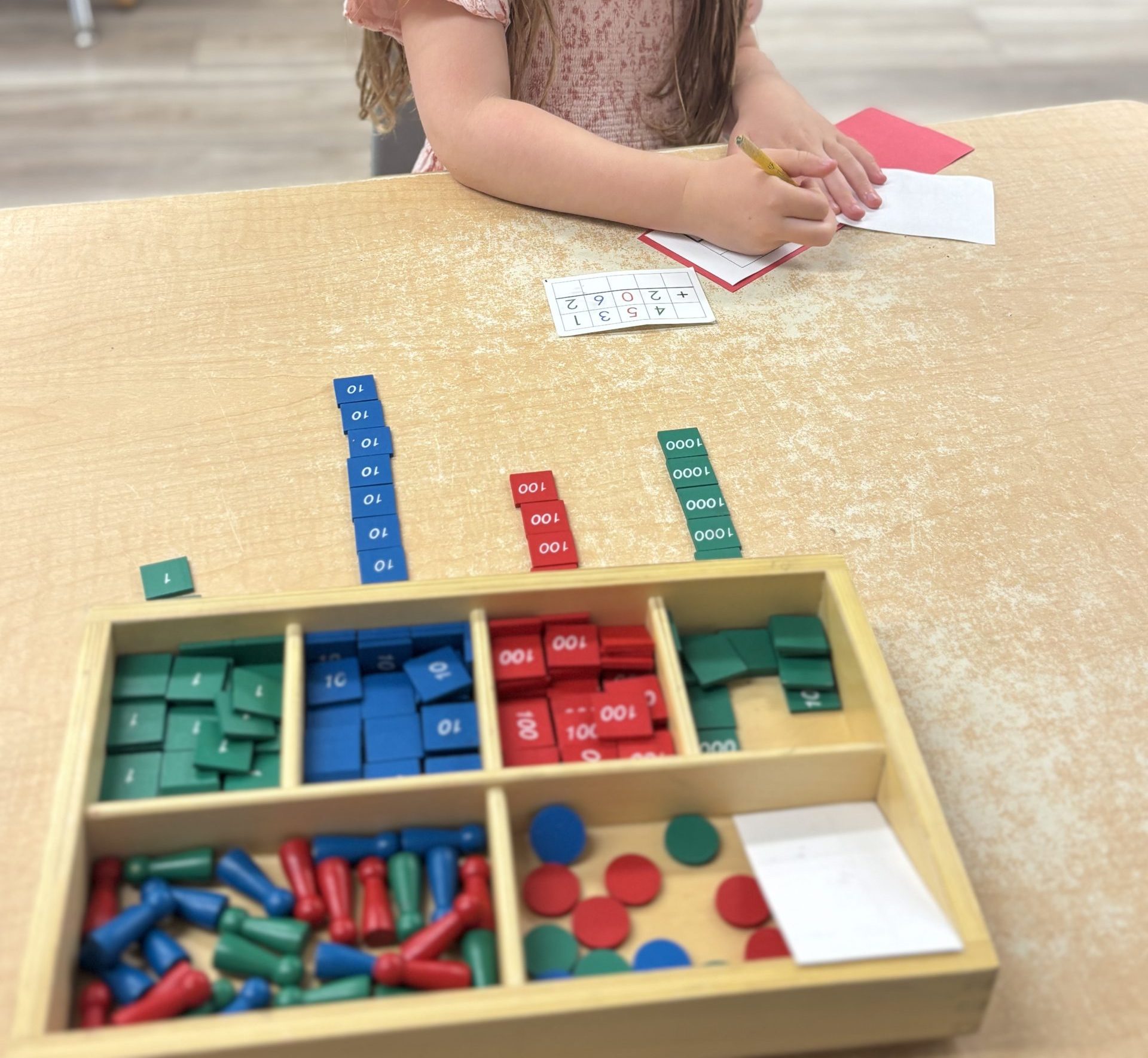 A child working at Christopher Academy Montessori School in Westfield, NJ on the Stamp Game